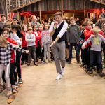 Eine Gruppe von Menschen steht in einem Raum mit einem Mann auf Skiern.