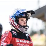 Mountainbiker mit Helm und GoPro, der ein rotes SRAM-Trikot trägt, blickt im Freien nach vorn.