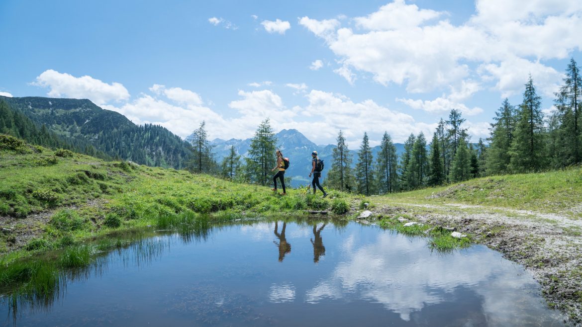 zwei Frauen (beide um die 30 Jahre alt) spiegeln sich in den Lacken des Lackenkogels.