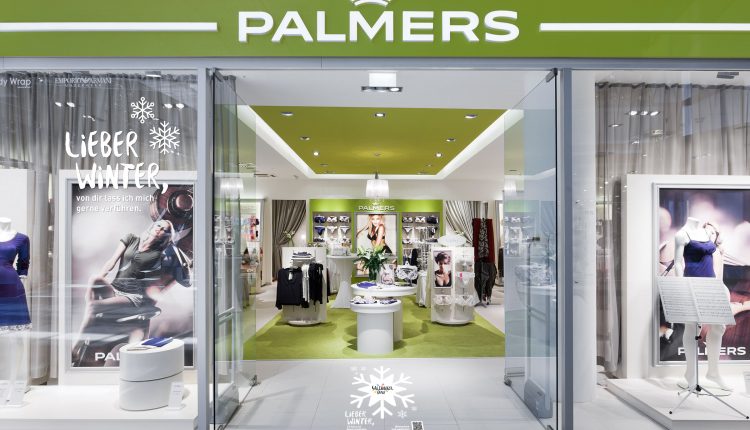 Schaufenster von Palmers mit grünem Schild, Schaufensterpuppen in Unterwäsche und moderner, gut beleuchteter Innenauslage.