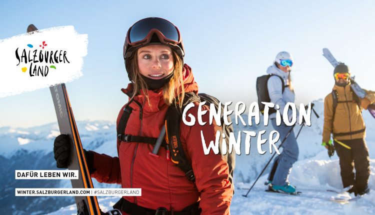 Drei Personen mit Skiern stehen auf einem verschneiten Berggipfel unter strahlend blauem Himmel, gekleidet in Winterkleidung.