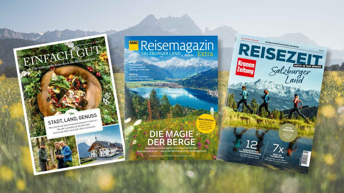 Drei Salzburger Reisemagazine vor einer malerischen Berg- und Wildblumenlandschaft.