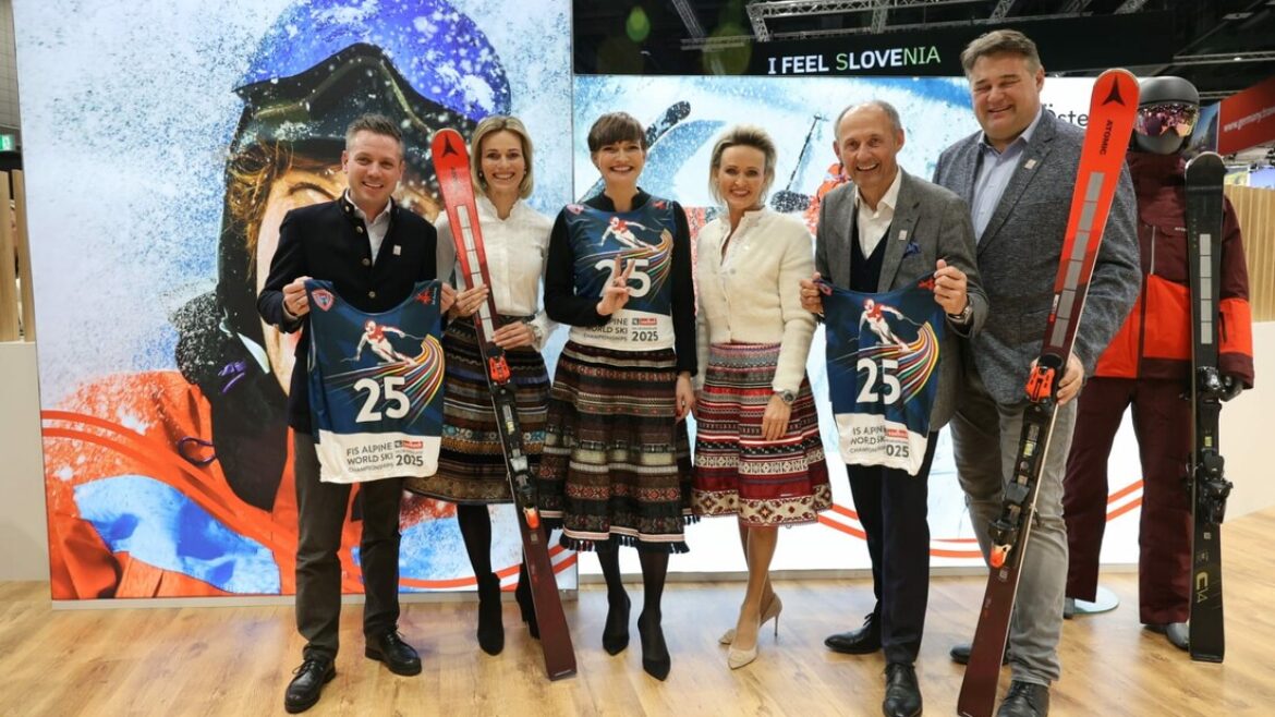 Sechs Personen posieren mit Skilätzchen und Skiern vor einer Skikulisse bei einer Indoor-Veranstaltung.