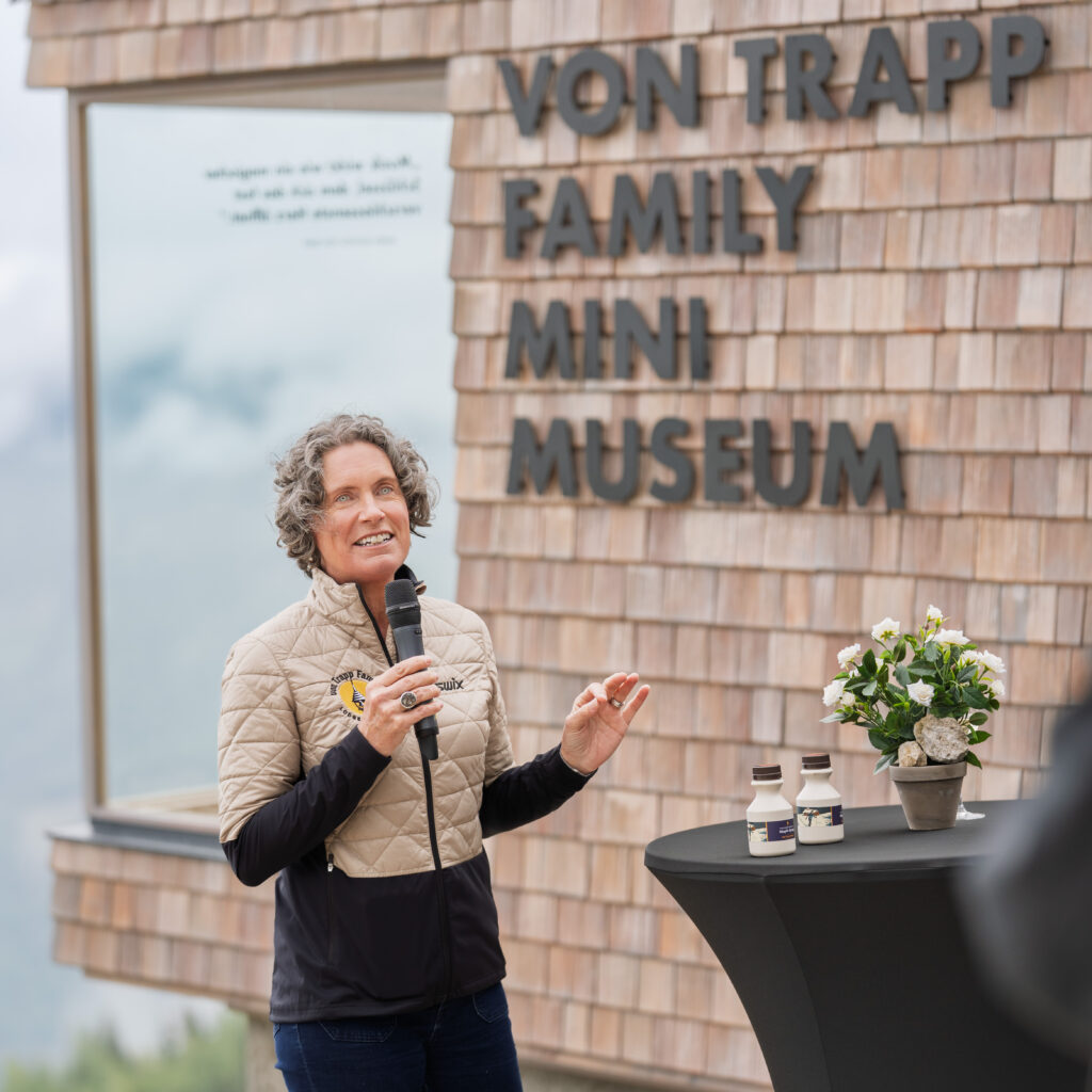 Eine Frau mit Mikrofon hält im Rahmen der Veranstaltung „Kulturelle Sommer-Highlights“ eine Rede im Von-Trapp-Familien-Mini-Museum.