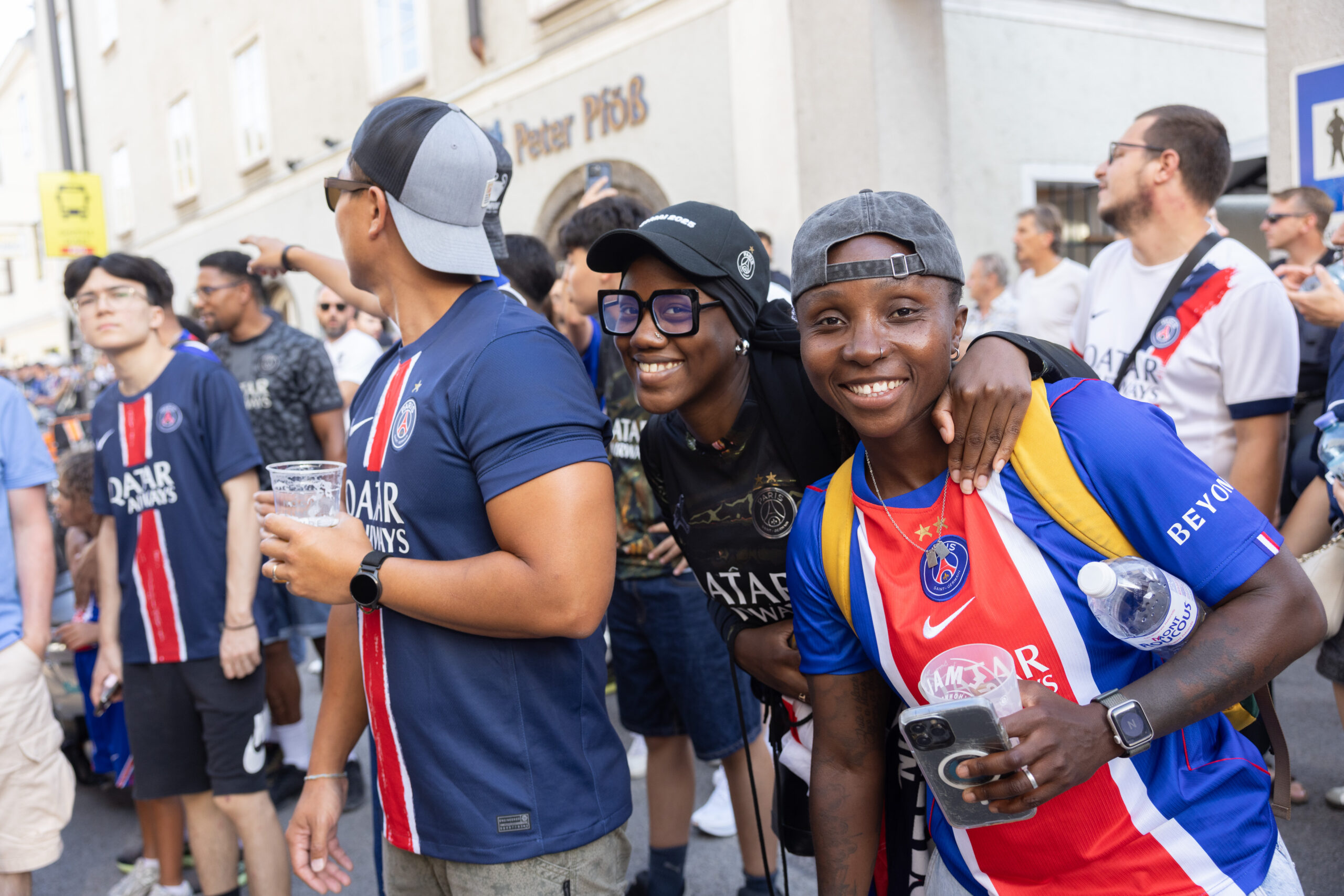 Menschen in PSG-Trikots lächeln und posieren