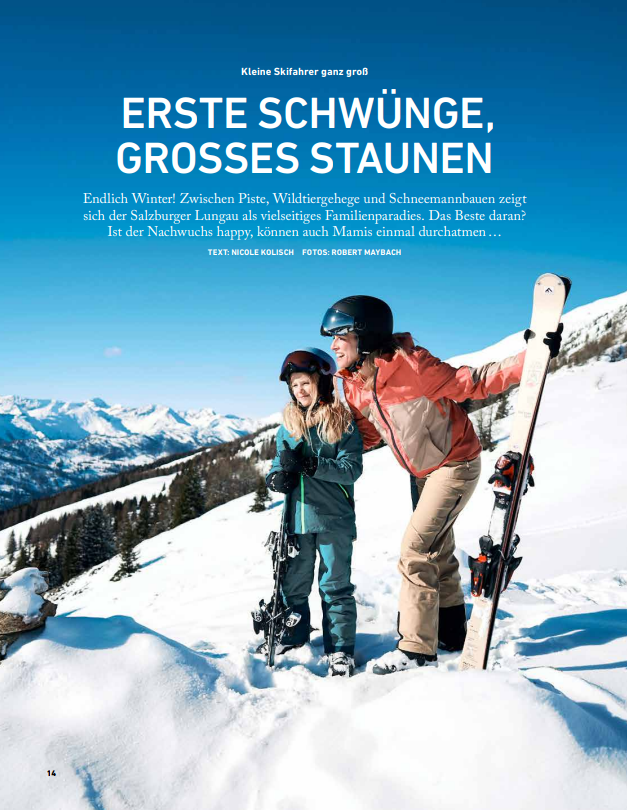 Ein lächelnder Erwachsener und ein Kind in Skikleidung posieren auf schneebedeckten Gipfeln – genau das Richtige für die Leser des Magazins „Jederzeit“.